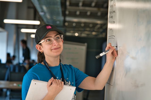 Hackathon Participant Drawing on Whiteboard